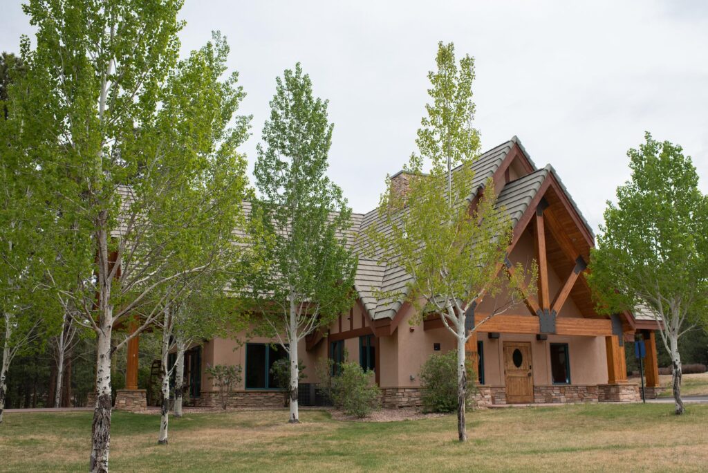The exterior of The Lodge at Cathedral Pines surrounded by Aspen trees