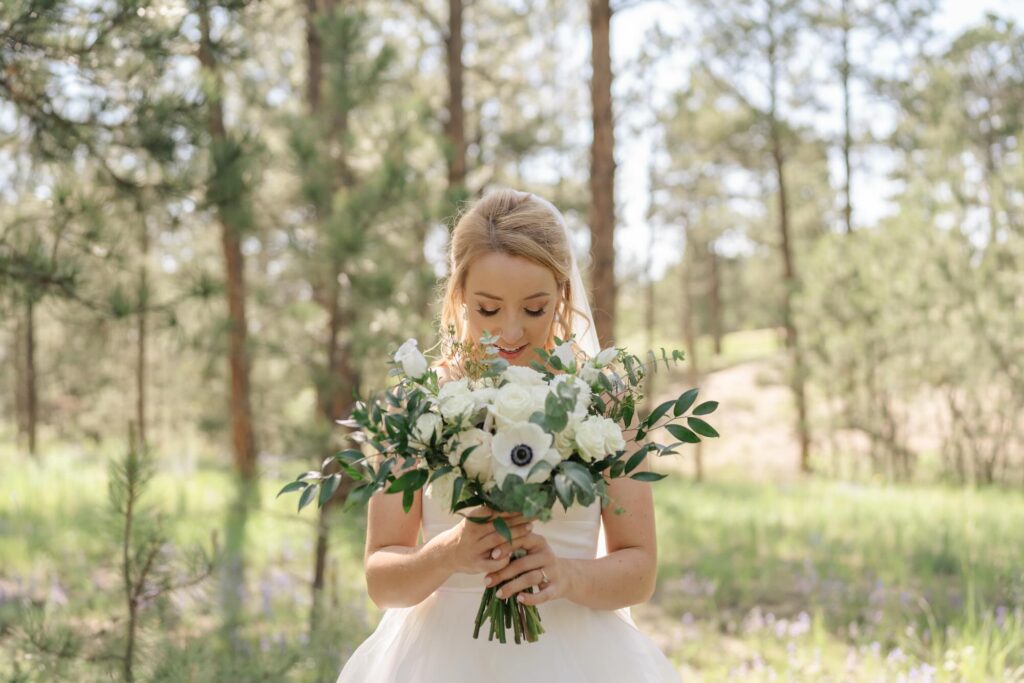 Bride with bouquet of flowers at a Colorado summer wedding at The Lodge at Cathedral Pines